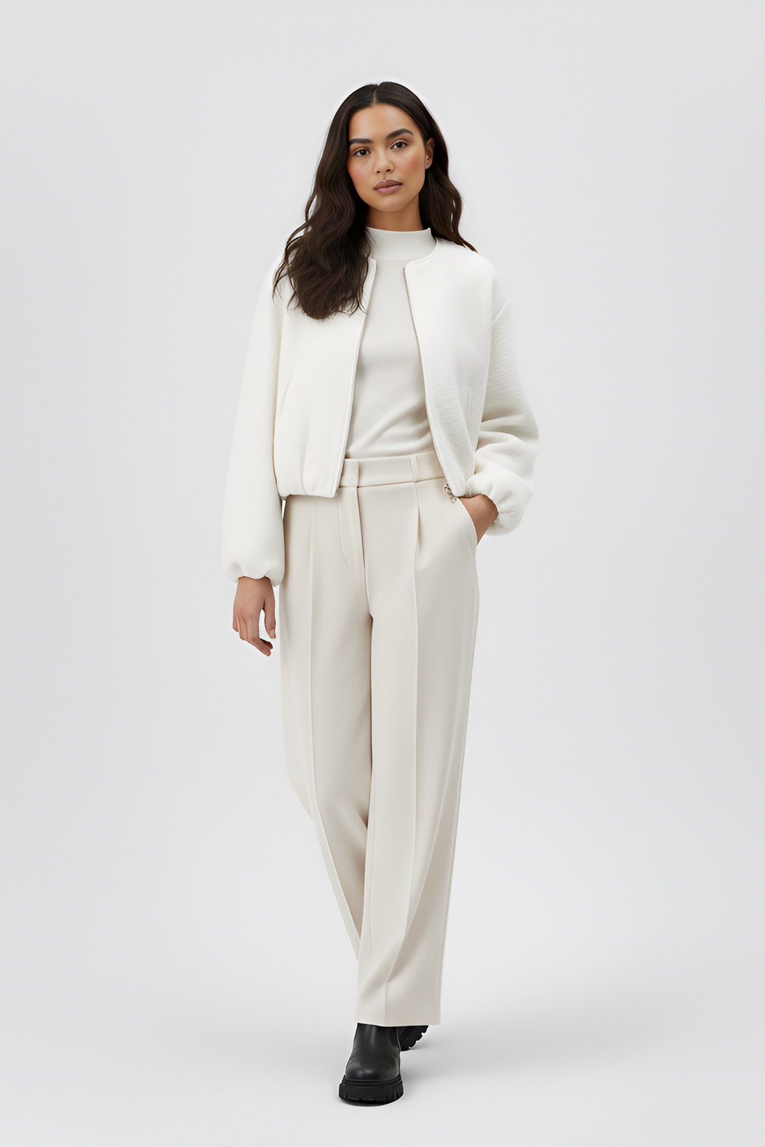 Woman wearing a white outfit with a jacket and pants on a white background