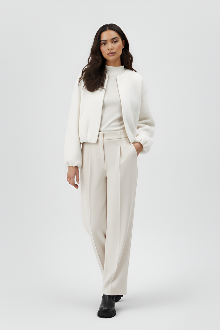 Woman wearing a white outfit with a jacket and pants on a white background