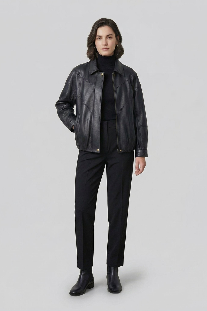 HAILEY - Woman wearing a black leather bomber jacket over a black turtleneck and trousers, front view