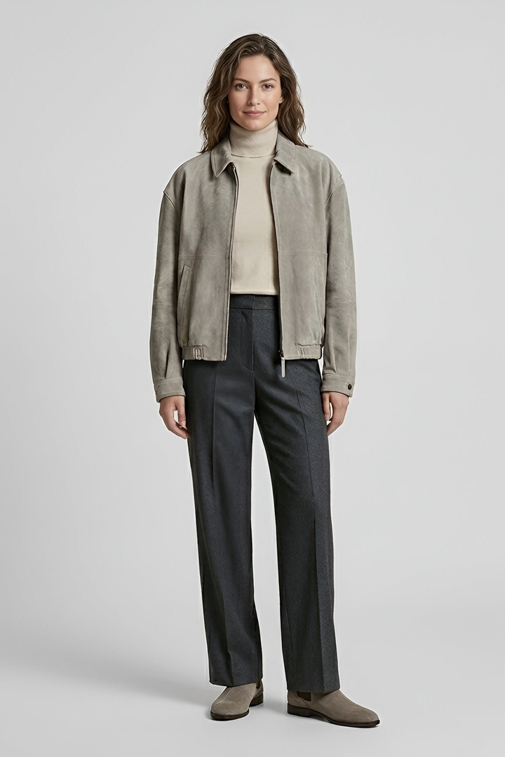 ROWAN - Woman wearing a light grey suede bomber jacket over a cream turtleneck and charcoal trousers, front view