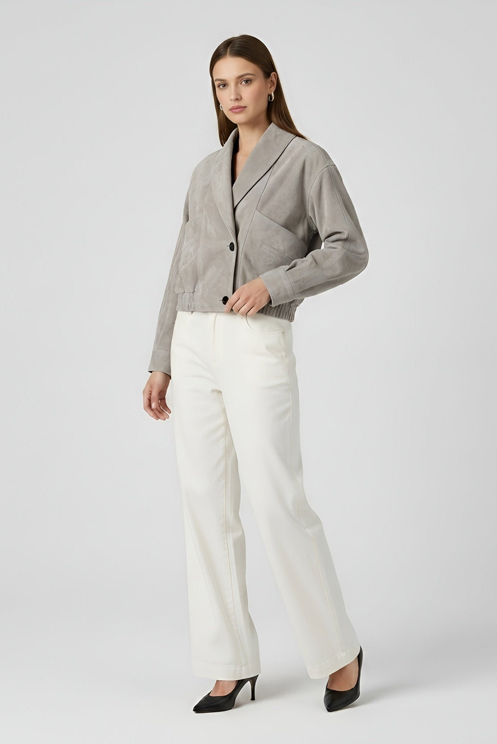 ELISE - Woman wearing a gray suede cropped bomber jacket with shawl collar and white wide-leg trousers, front three-quarter view