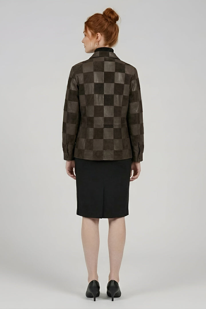 Person wearing a checkered jacket and black skirt on a plain background