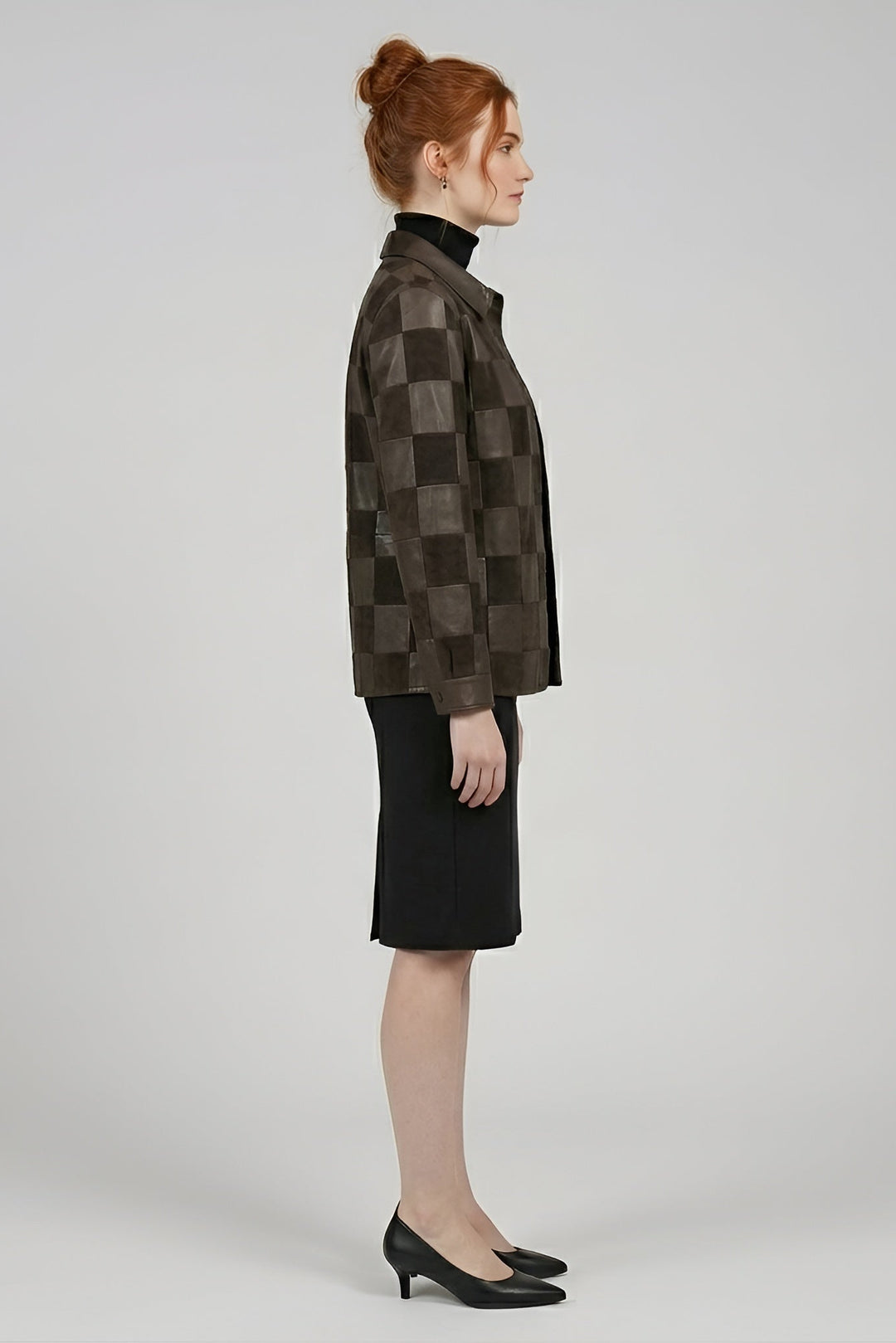 Woman wearing a checkered brown jacket and black skirt on a white background